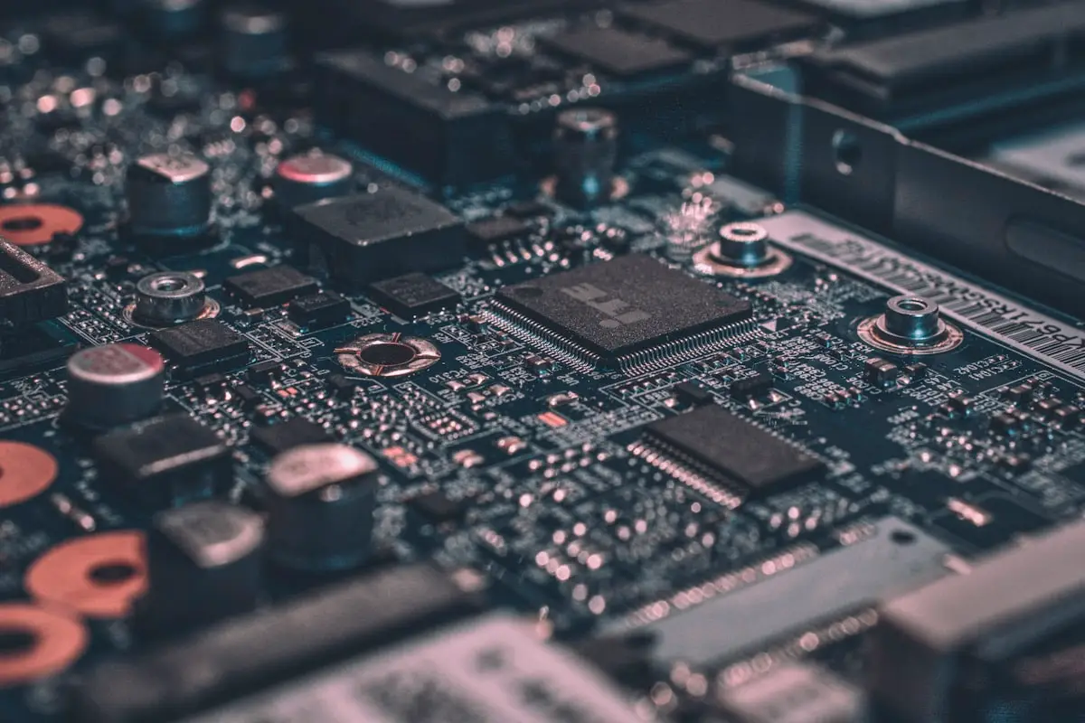 The Krehzy Good Guide to Business Automation: 5 Clear Signs You’re Ready to Scale 2 Close-up view of a computer motherboard showing intricate electronic components, including microchips, capacitors, and circuit pathways, with a dark color scheme and blurred background elements.