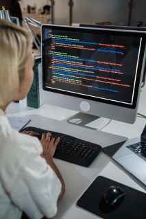 vertical shot of woman typing a multicoloured code